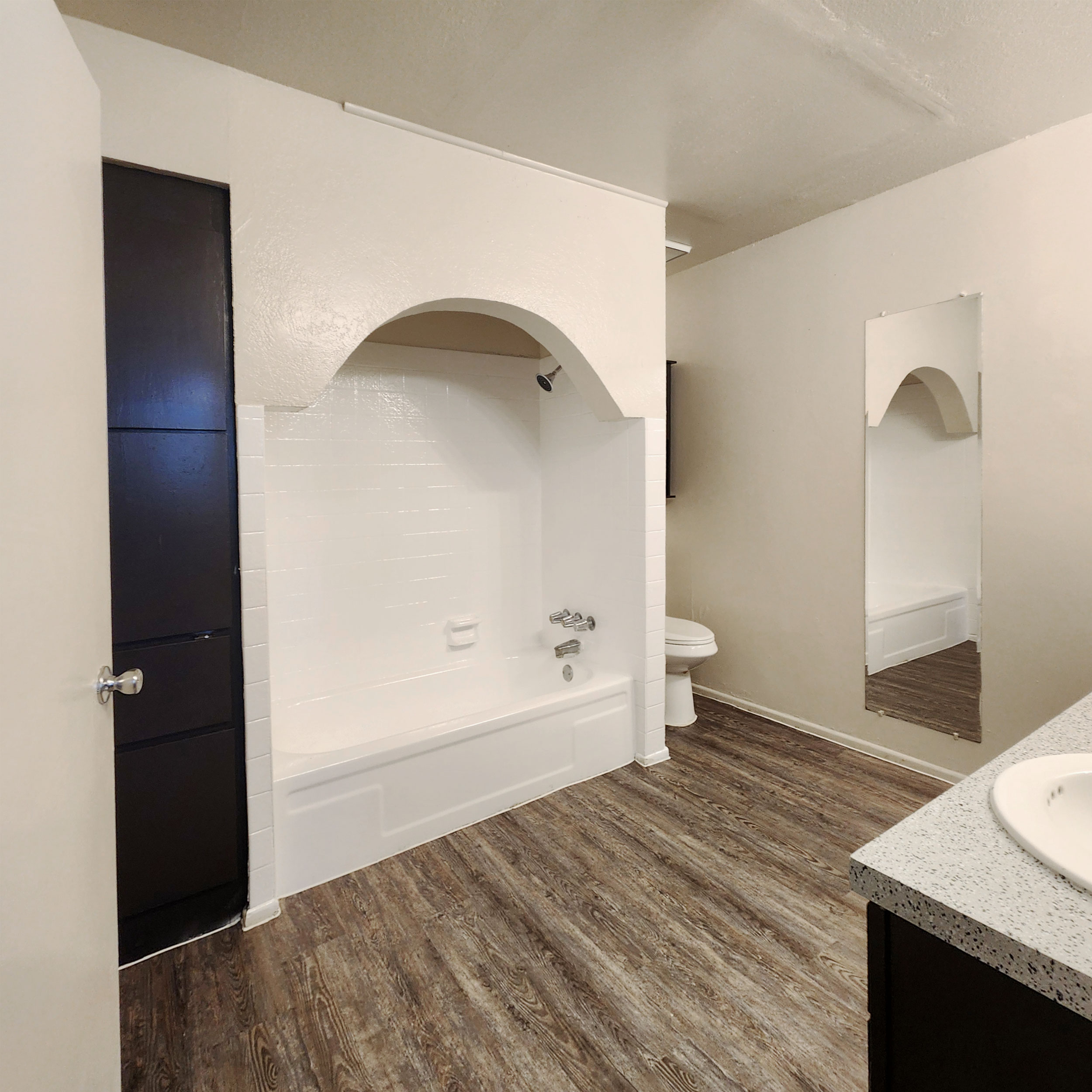 Bathroom with an arched tub surround and built-in storage